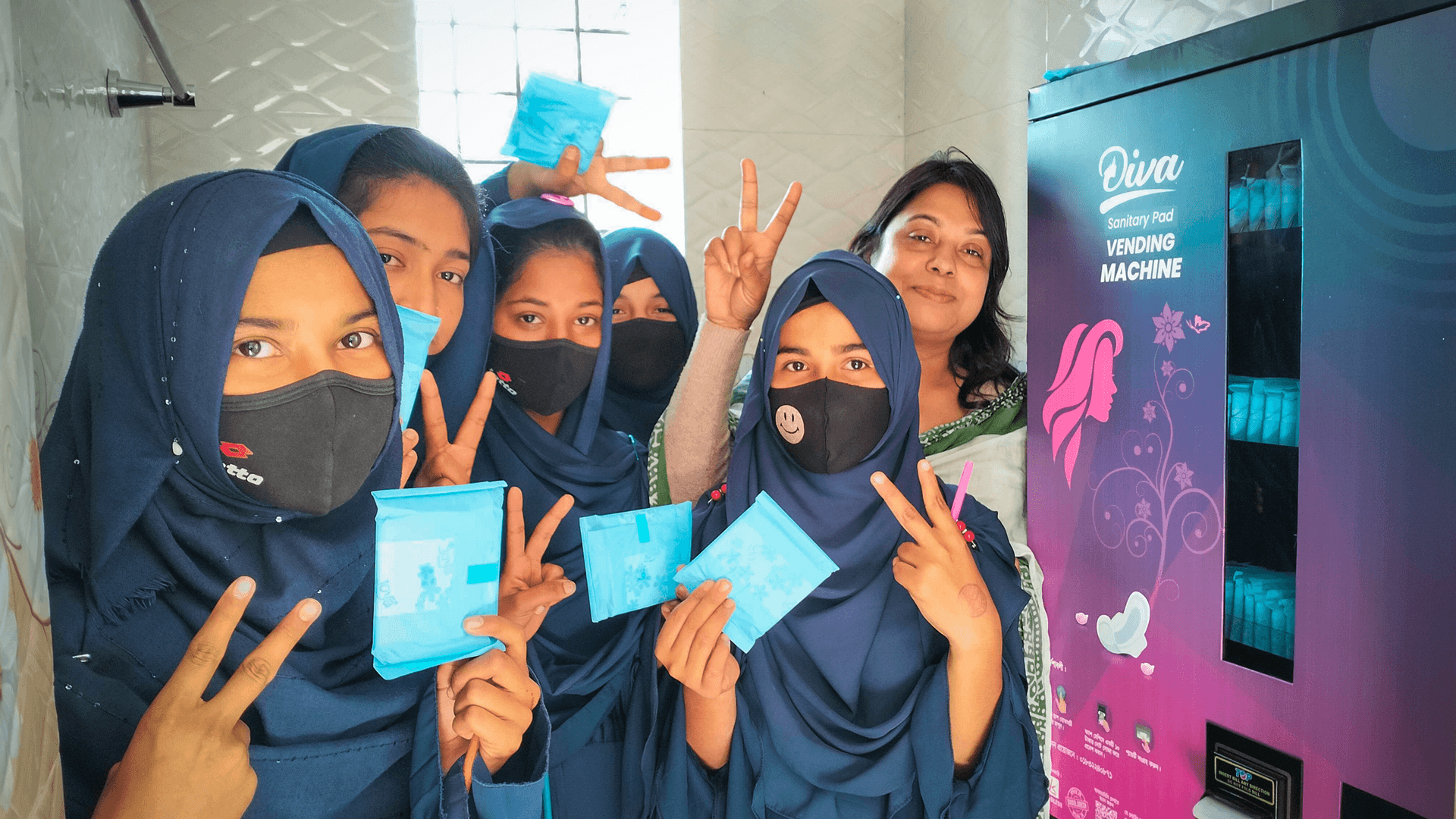 Schoolgirls using sanitary pad vending machine 